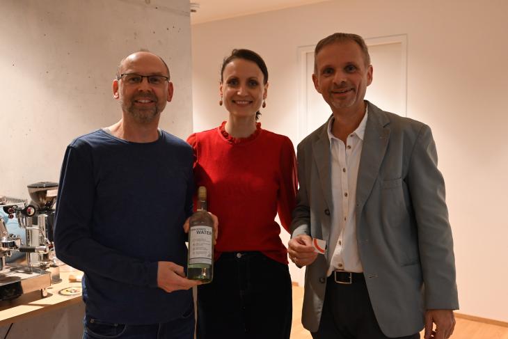 Ein Mitglied ersteigert zur Eröffnung eine Flasche Open Source Water